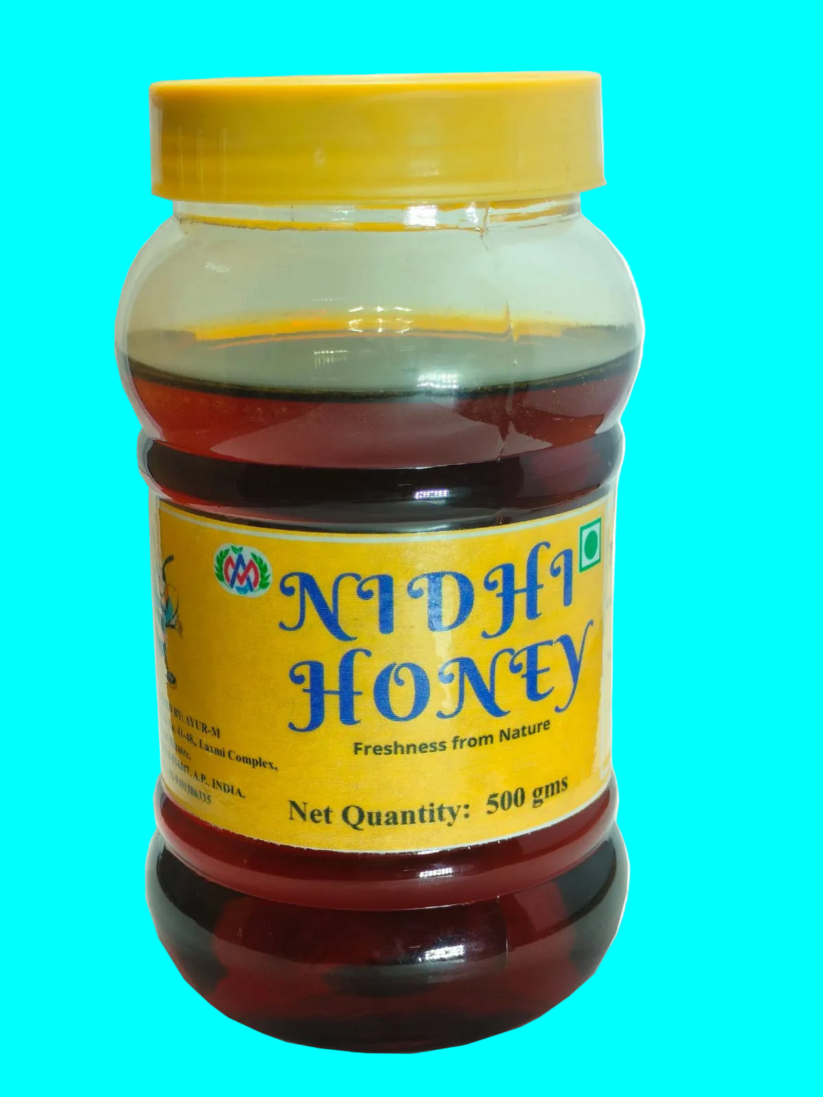 A 500g plastic jar of Nidhi Honey with a yellow lid and yellow label, filled with dark amber honey, shown against a plain white background.