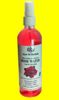 A bottle of Ayur M Herbals Rose Water Face Toner with pink liquid inside, a white spray top, and a white label featuring a red rose graphic.