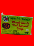 A rectangular box of Ayur M Herbals Hand Made Red Sandal Soap, featuring a bright yellow-green label with red and green text, photographed on a plain off-white background.